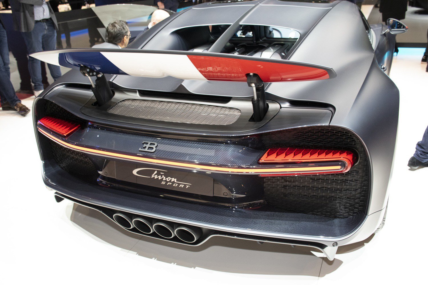 Rear view of supercar with raised spoiler and quad exhaust pipes
