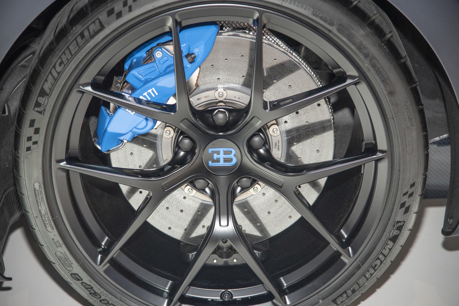 Black alloy wheel with blue brake caliper and perforated disc
