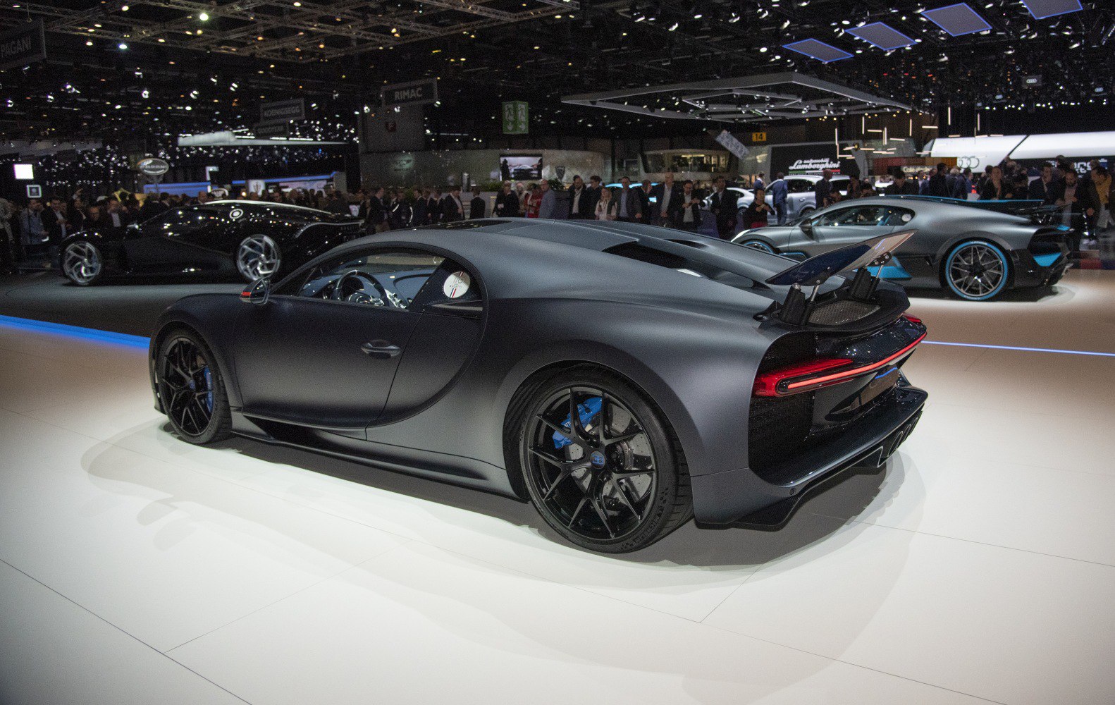 Matte black supercar with raised rear spoiler and black alloy wheels