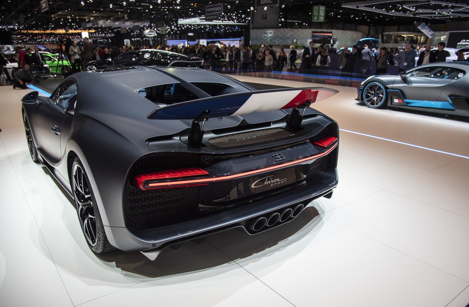Rear view of a supercar with a tricolor active spoiler and quad exhausts