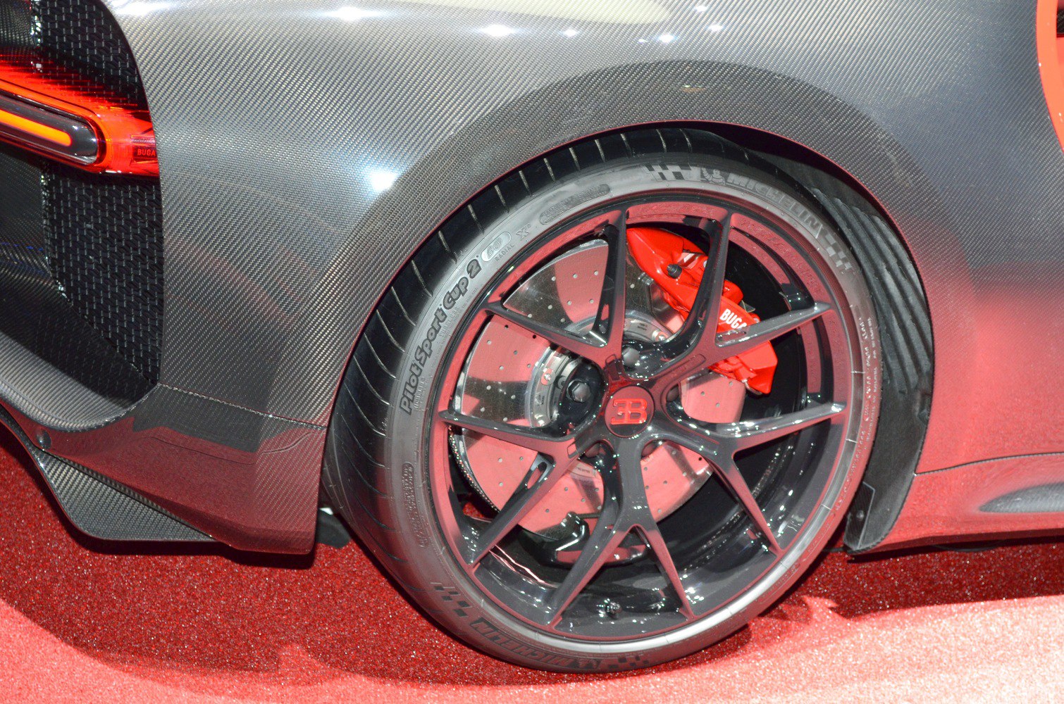 Rear wheel with red brake caliper and carbon fiber panel