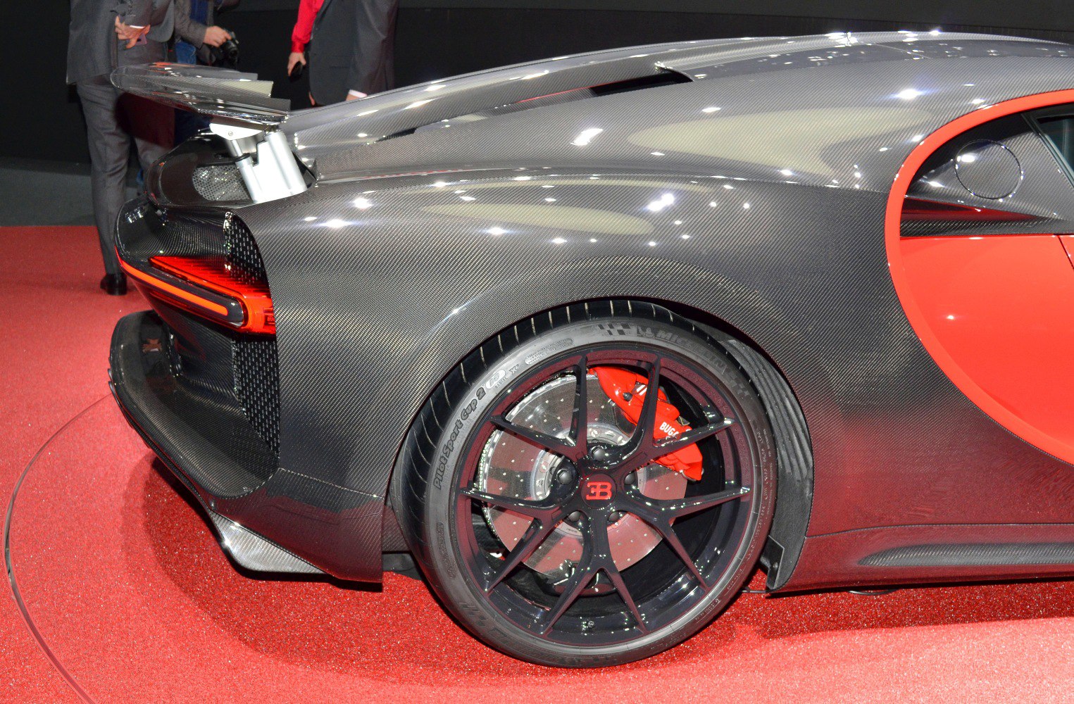 Rear wheel with red brake caliper and carbon fiber body panel