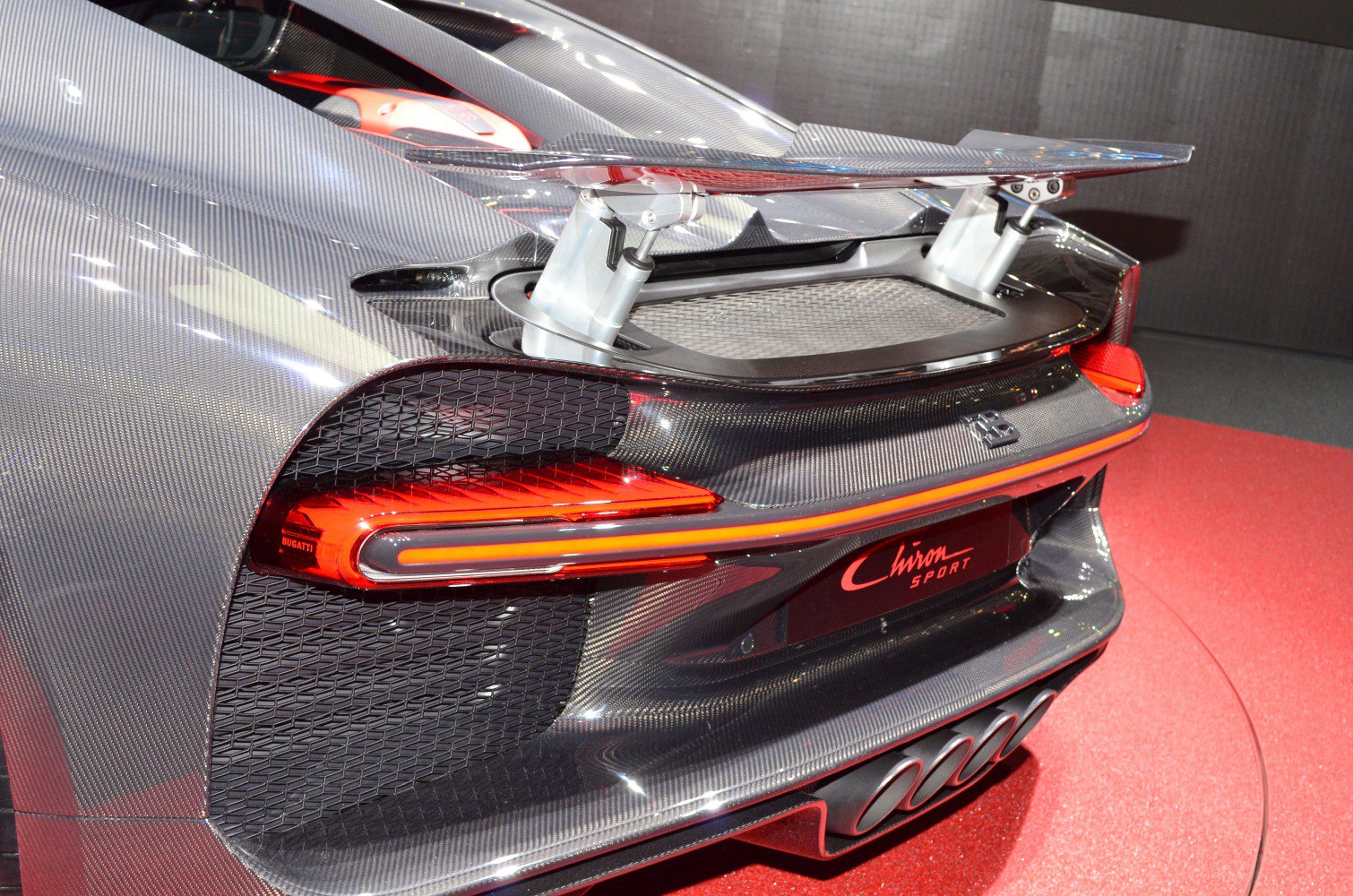 Carbon fiber rear wing with LED tail lights on supercar rear