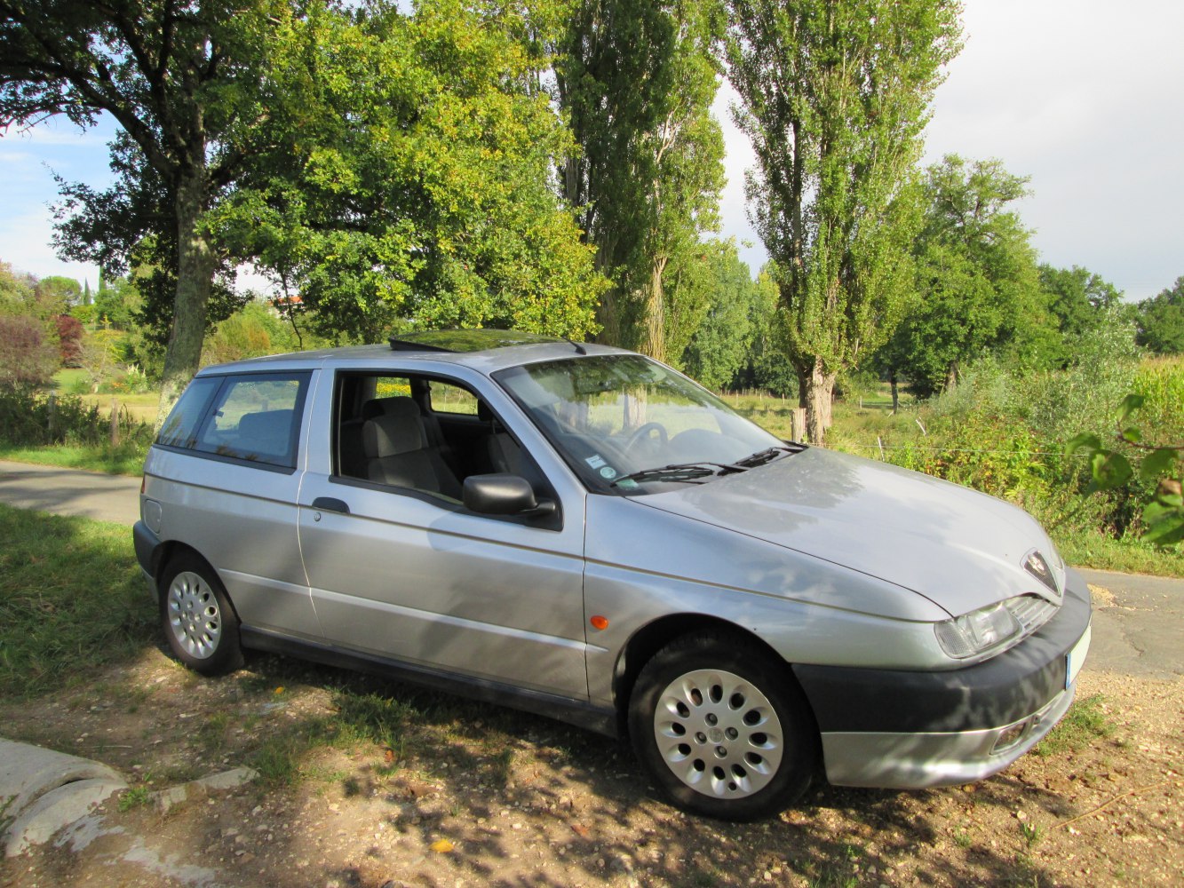 Side profile of blue compact hatchback with unique wheels