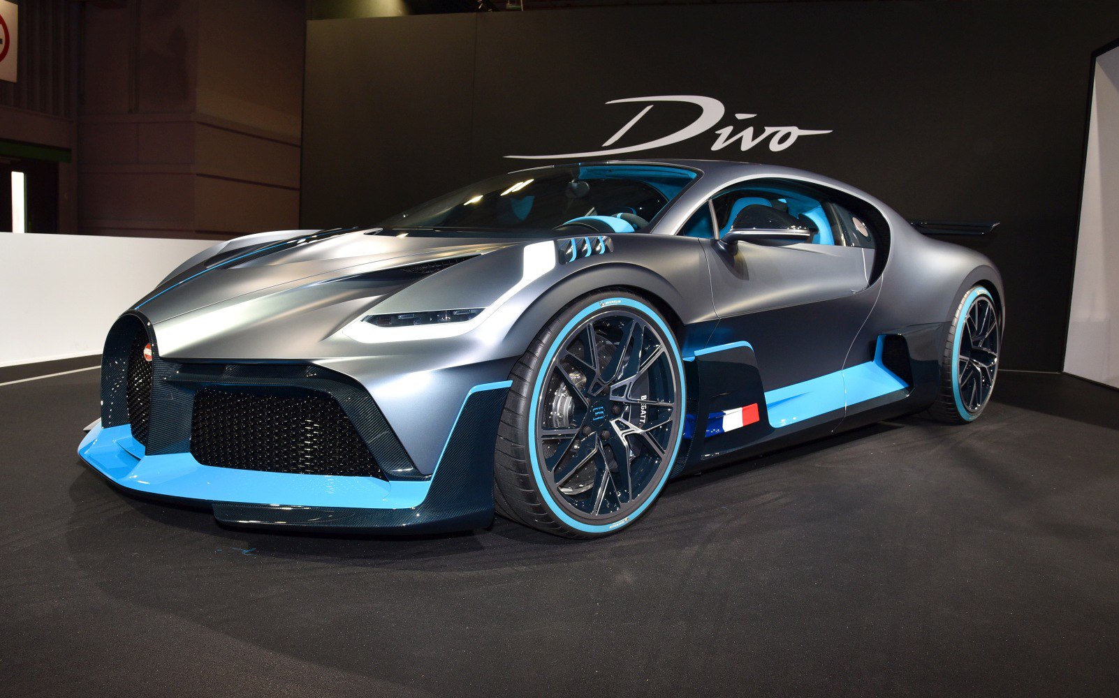 Aerodynamic front bumper with large, intricate alloy wheels and blue accents