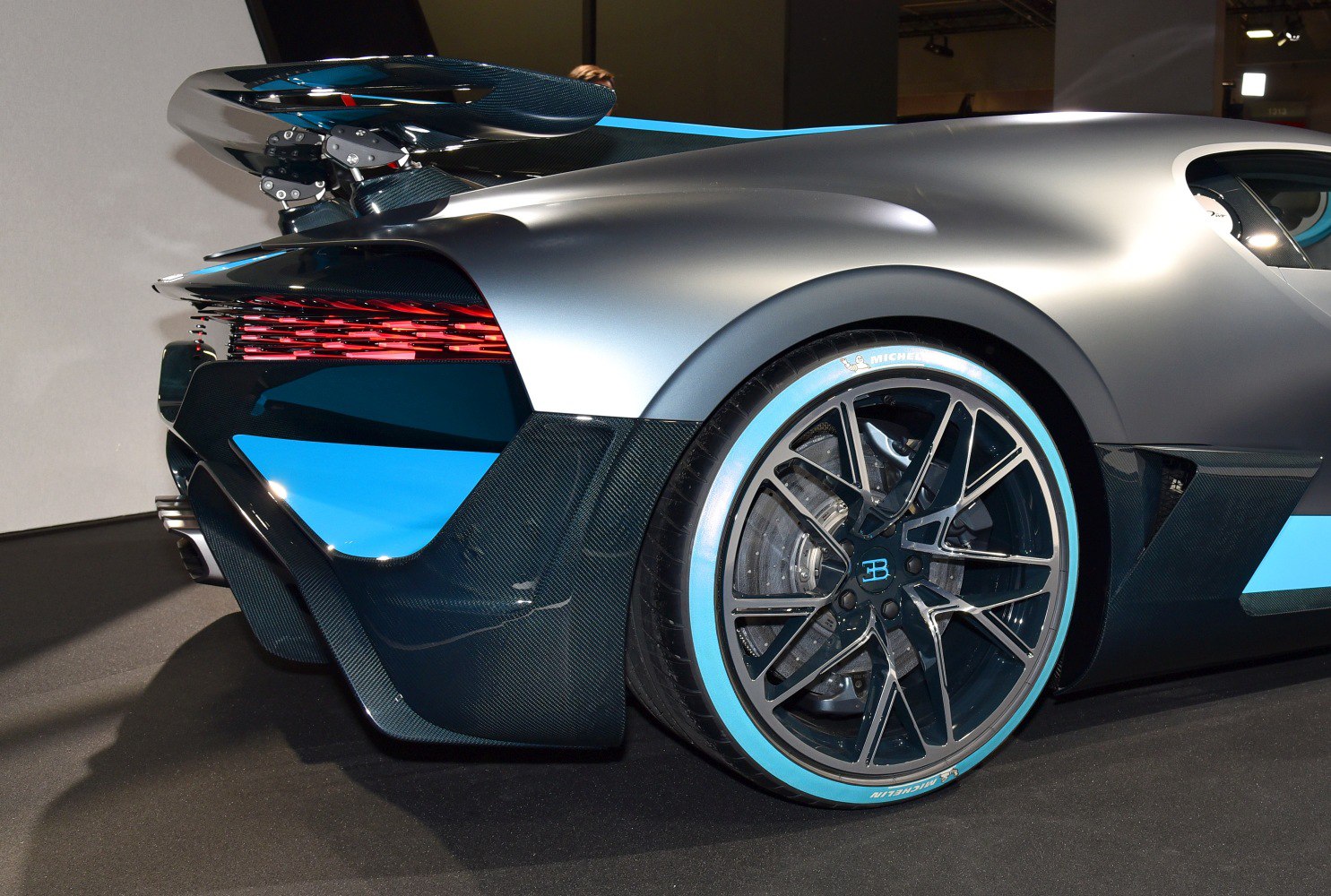 Close-up of rear wheel, tire with blue accents, and aerodynamic spoiler.