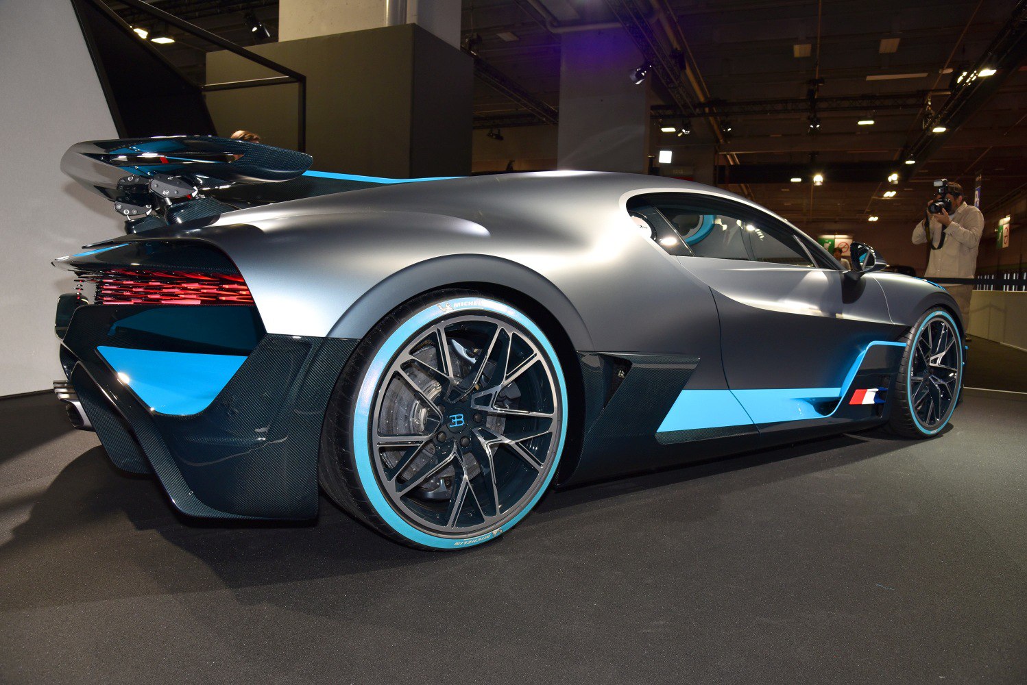 Rear side view with aerodynamic sculpted body and blue-accented wheels