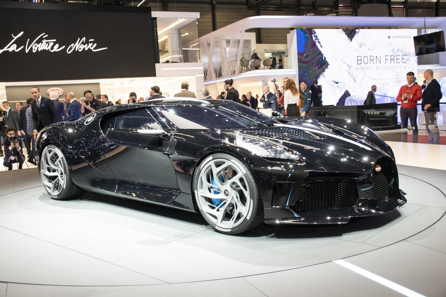 Black hypercar with aerodynamic body and premium wheels in showroom