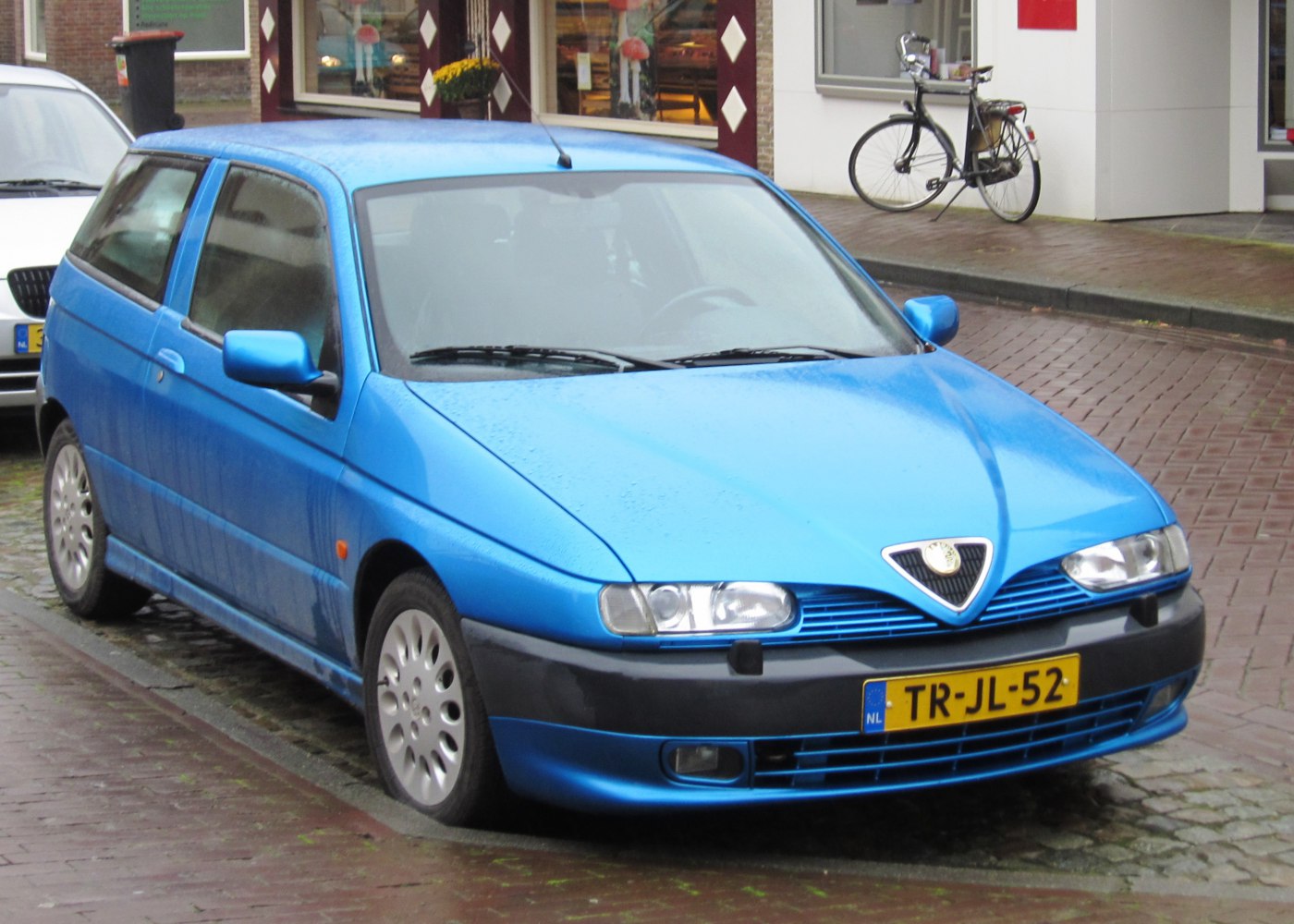 Blue hatchback with dual headlights and aerodynamic grille