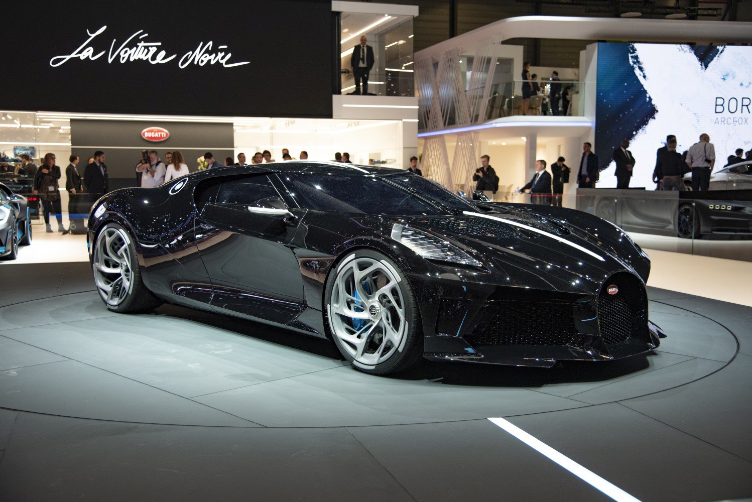 Sleek aerodynamic black supercar with unique alloy wheels.