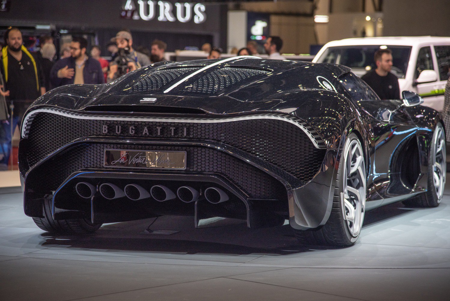 Rear view of a hypercar with six exhaust pipes and honeycomb grille