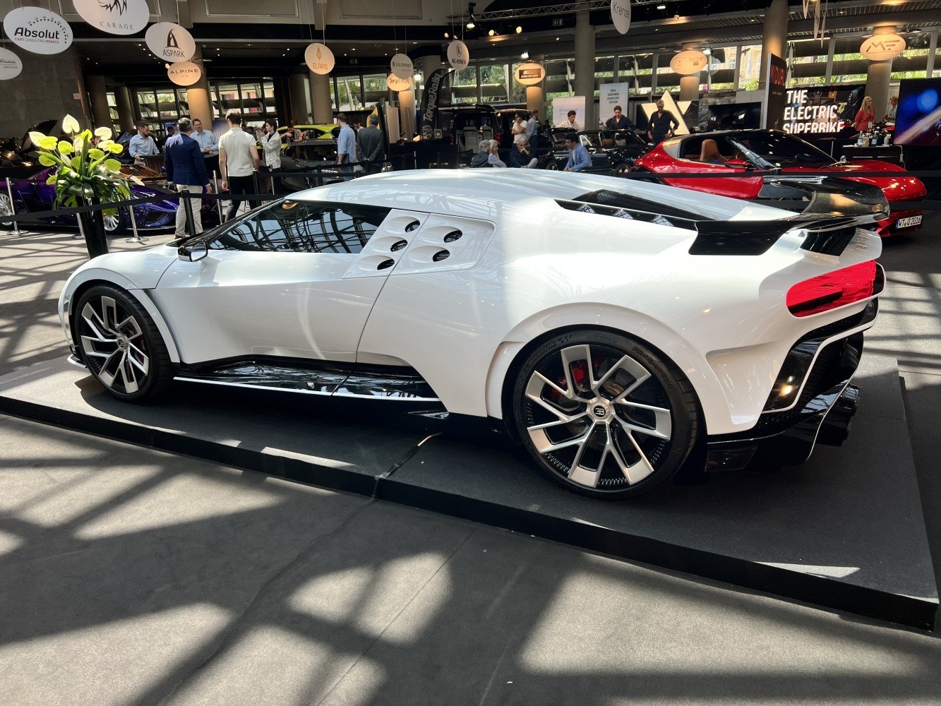 White sports coupe with rear wing and unique side aero vents