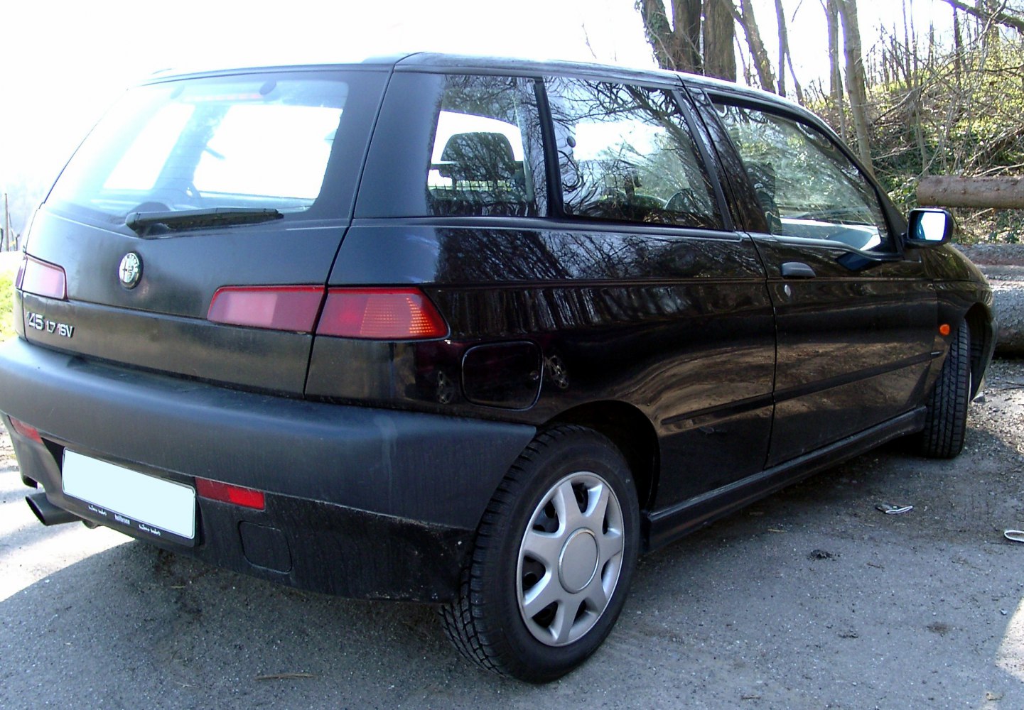 Rear side view of a compact black hatchback with distinctive taillights.