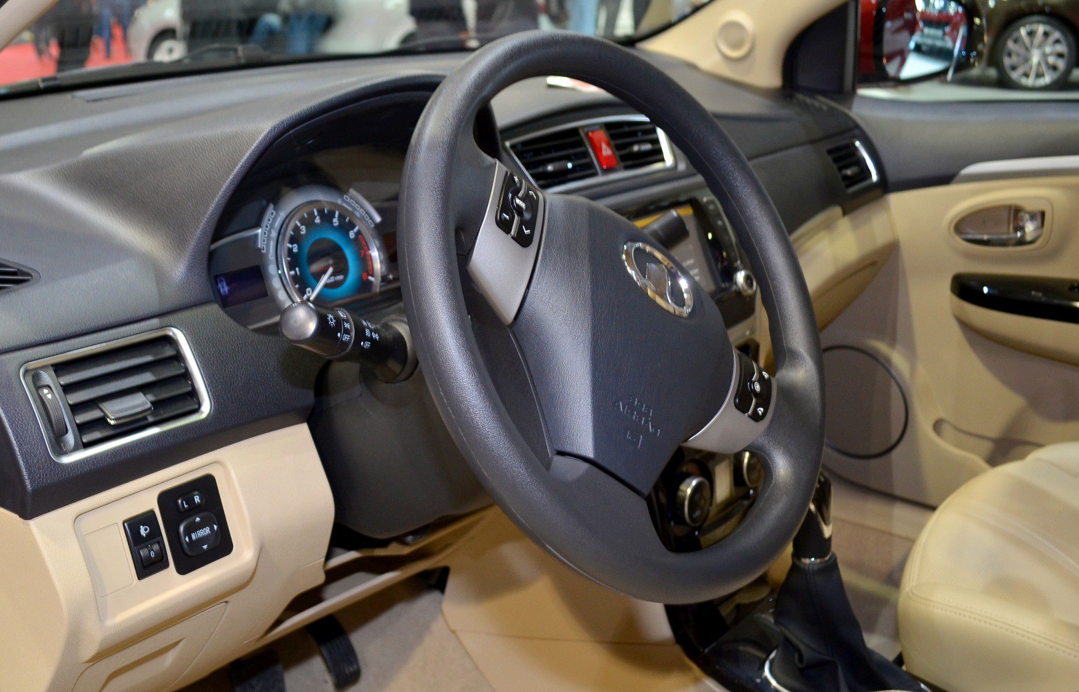 Car steering wheel and dashboard with beige interior upholstery
