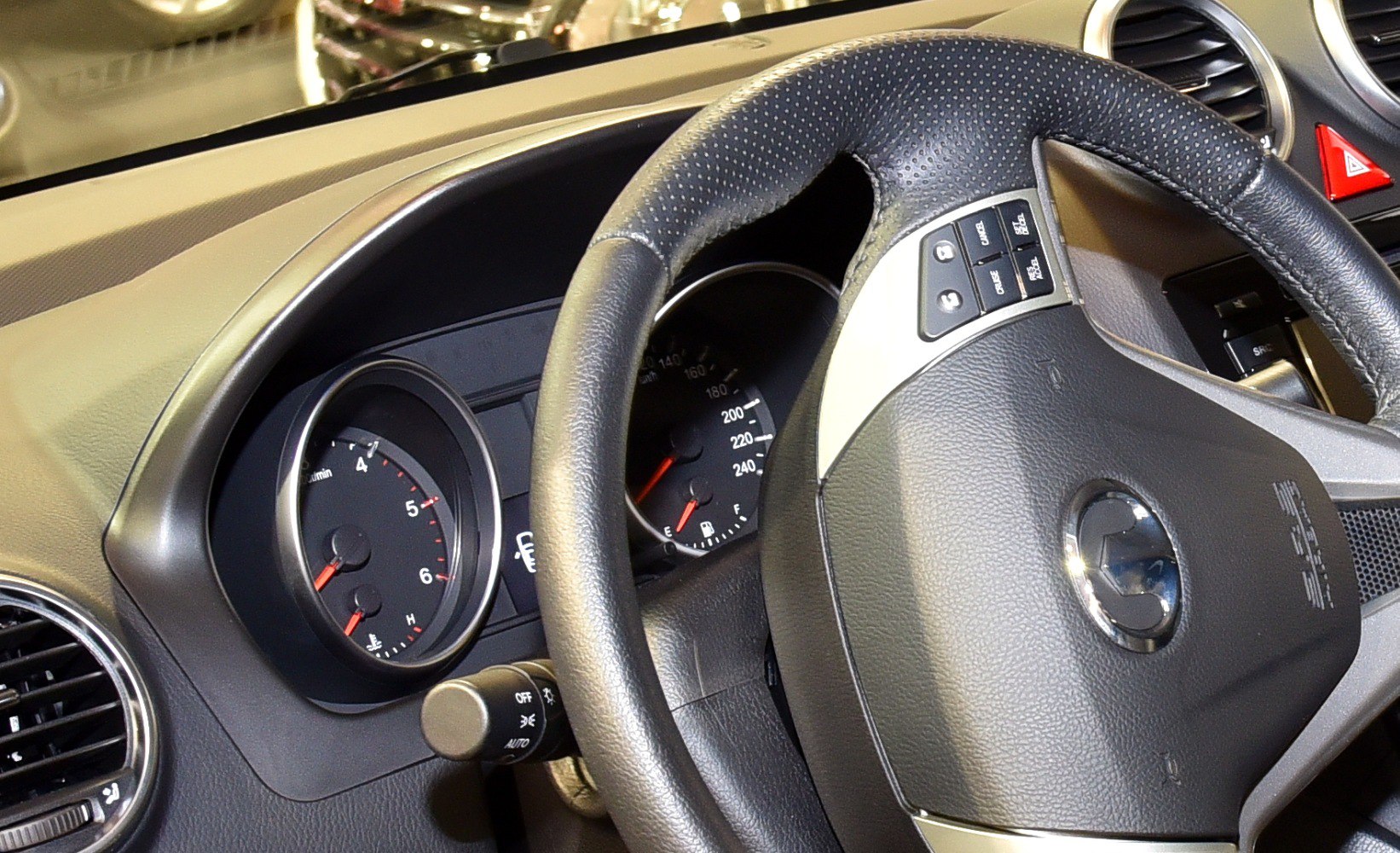Steering wheel with control buttons and dashboard gauges
