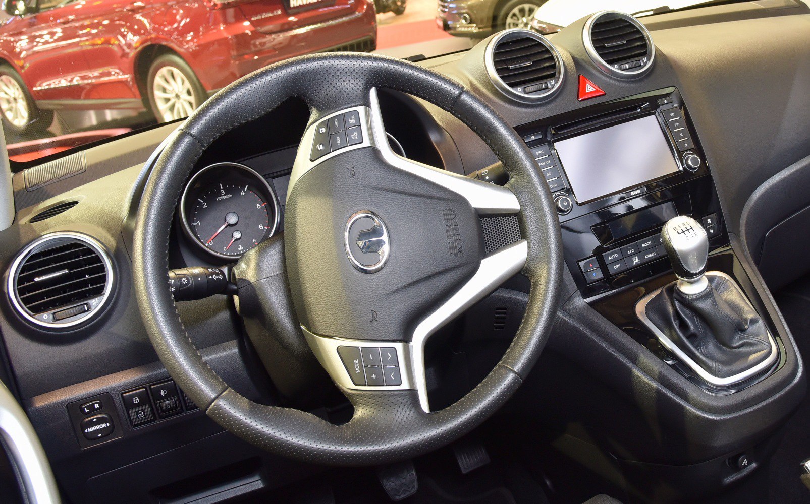 Manual gear shift and multifunction steering wheel in car interior