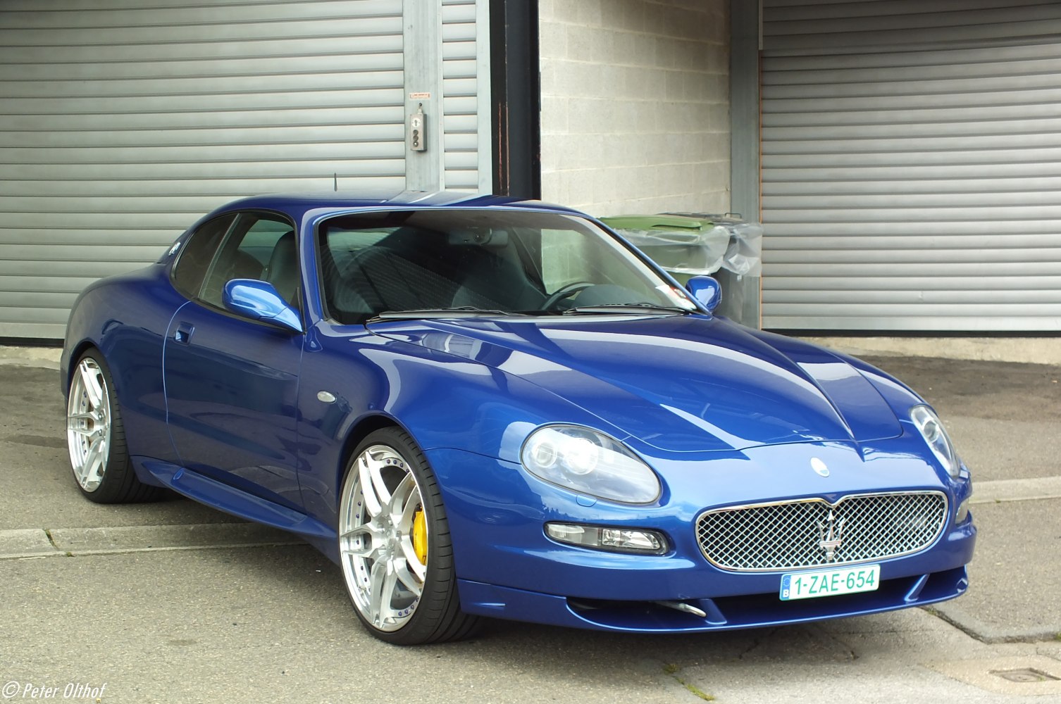 Front three-quarter view of sleek blue sports coupe with prominent grille.