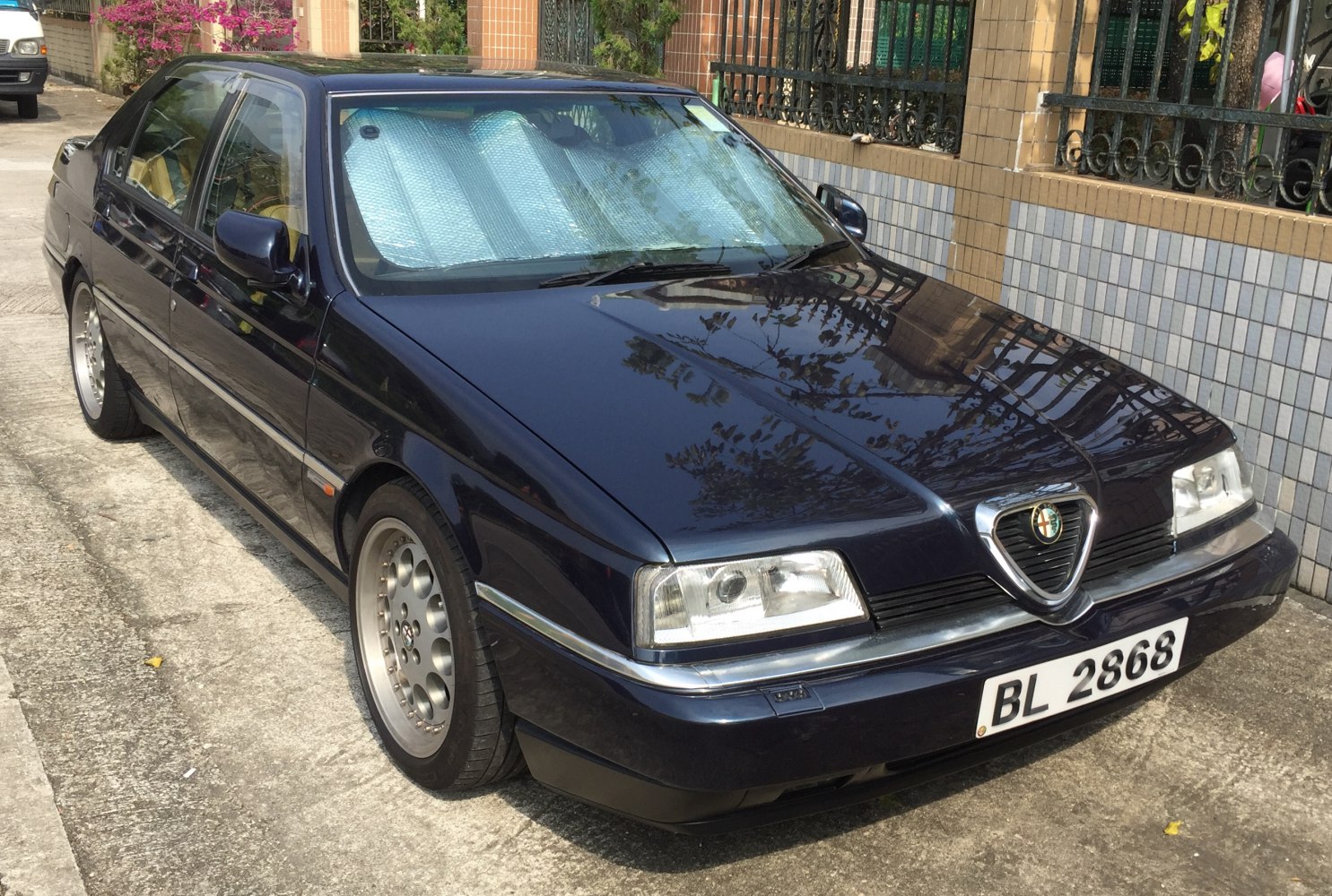 Front and side view of a sedan with distinctive triangular grille and rectangular headlights.