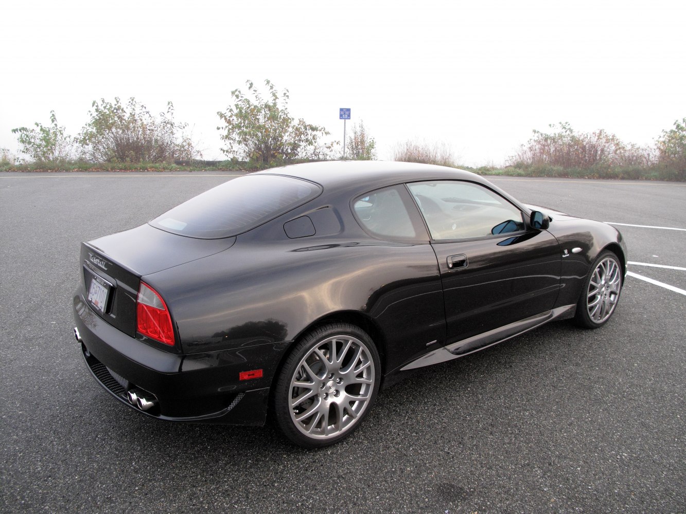 Sleek rear side view with alloy wheels and quad exhaust pipes