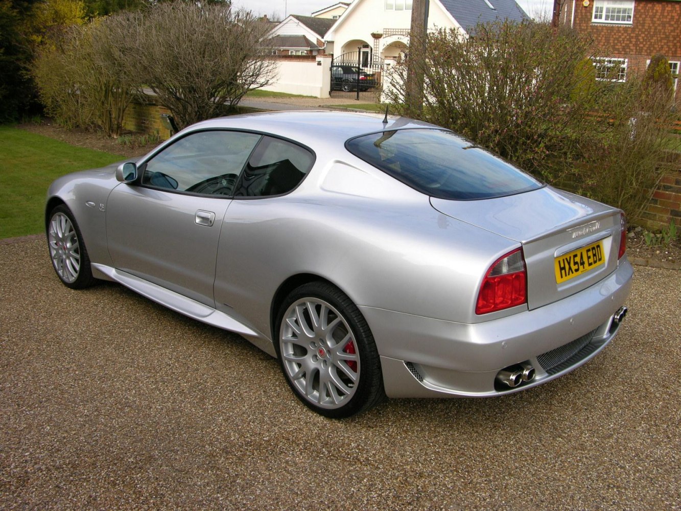 Silver coupe side profile with alloy wheels and dual exhaust