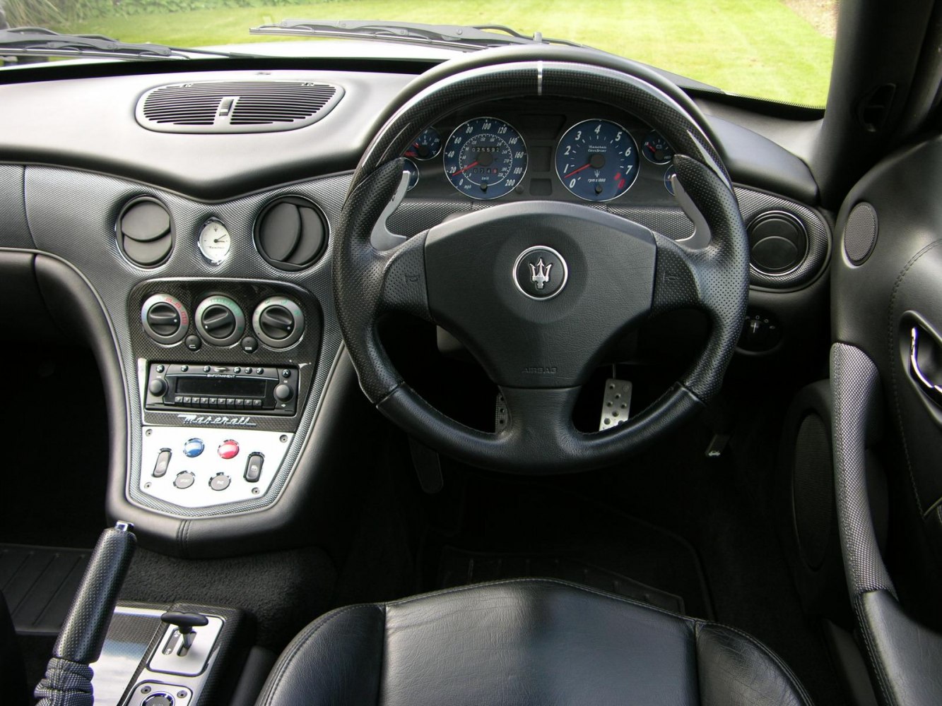 Luxury sports car dashboard with carbon fiber trim and detailed instrumentation