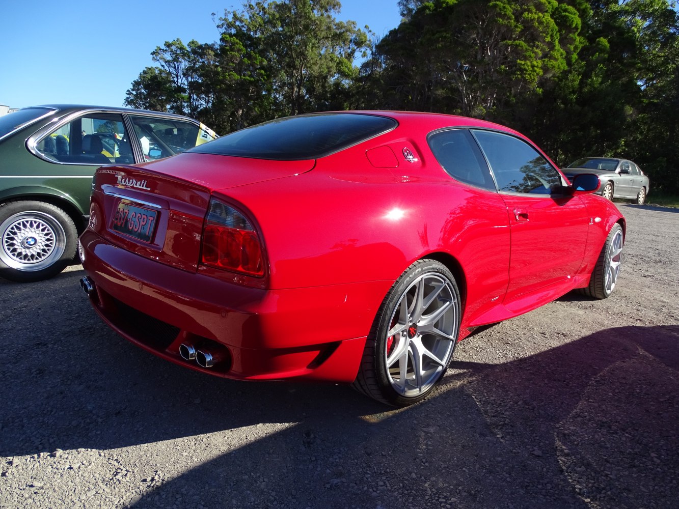 Rear view of red sports coupe with custom alloy wheels and dual exhaust