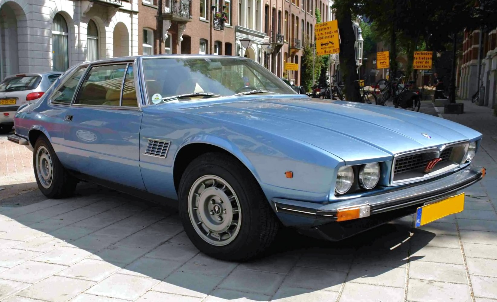 Vintage coupe with dual round headlights and sleek blue body
