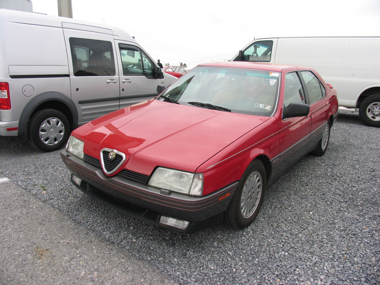 Red sedan with triangular grille and rectangular headlights from front angle