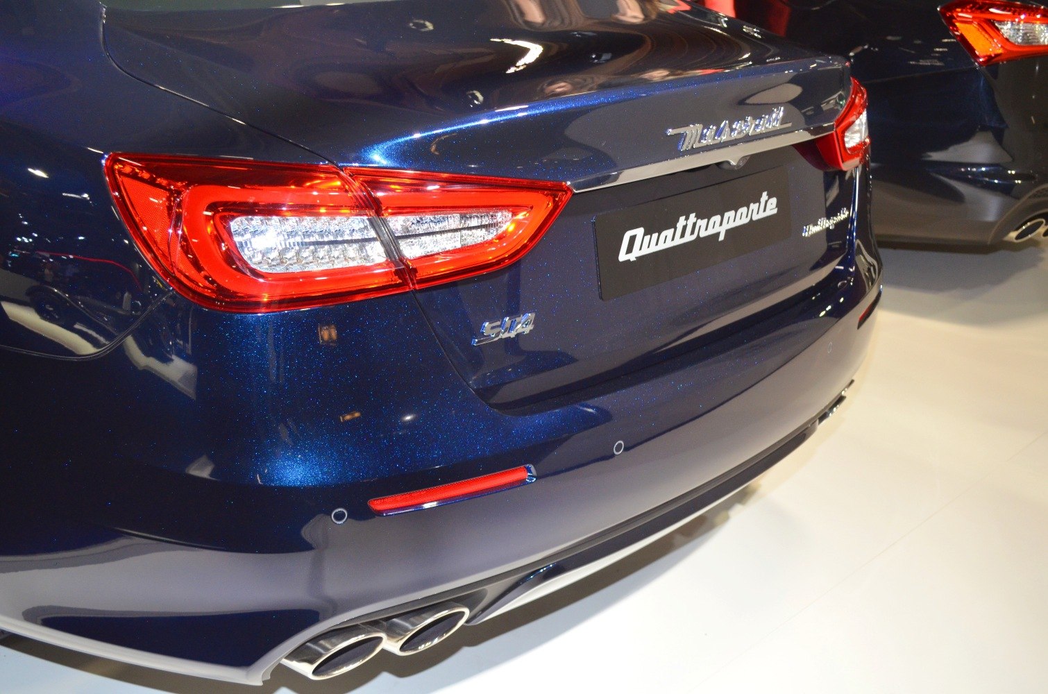 Close-up of rear tail light and quad exhausts with metallic blue paint
