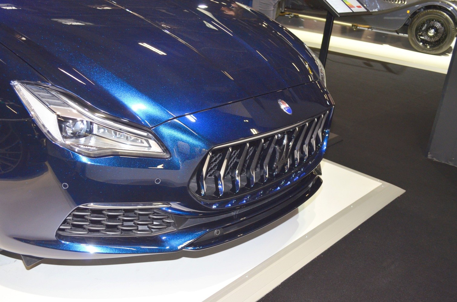 Front grille and headlight close-up of a luxury sedan.