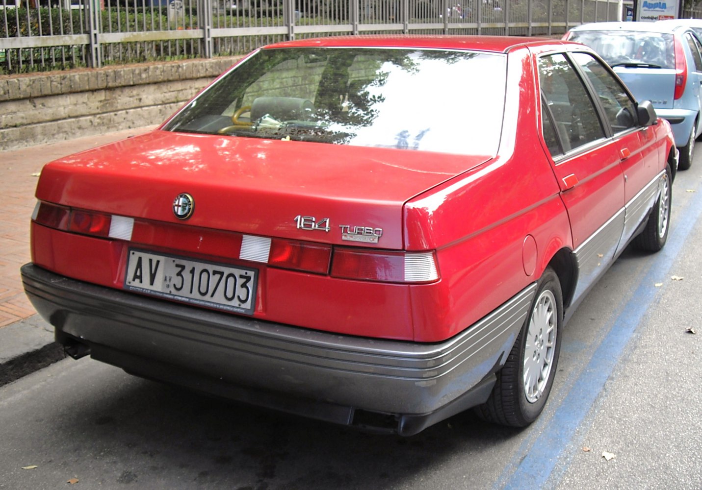 Red classic sedan rear with distinctive taillights and turbo badge
