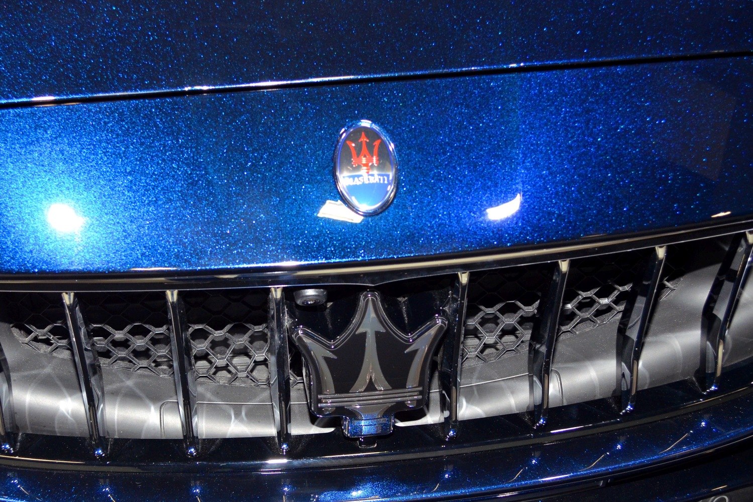 Front grille with Maserati emblem and trident logo on metallic blue paint