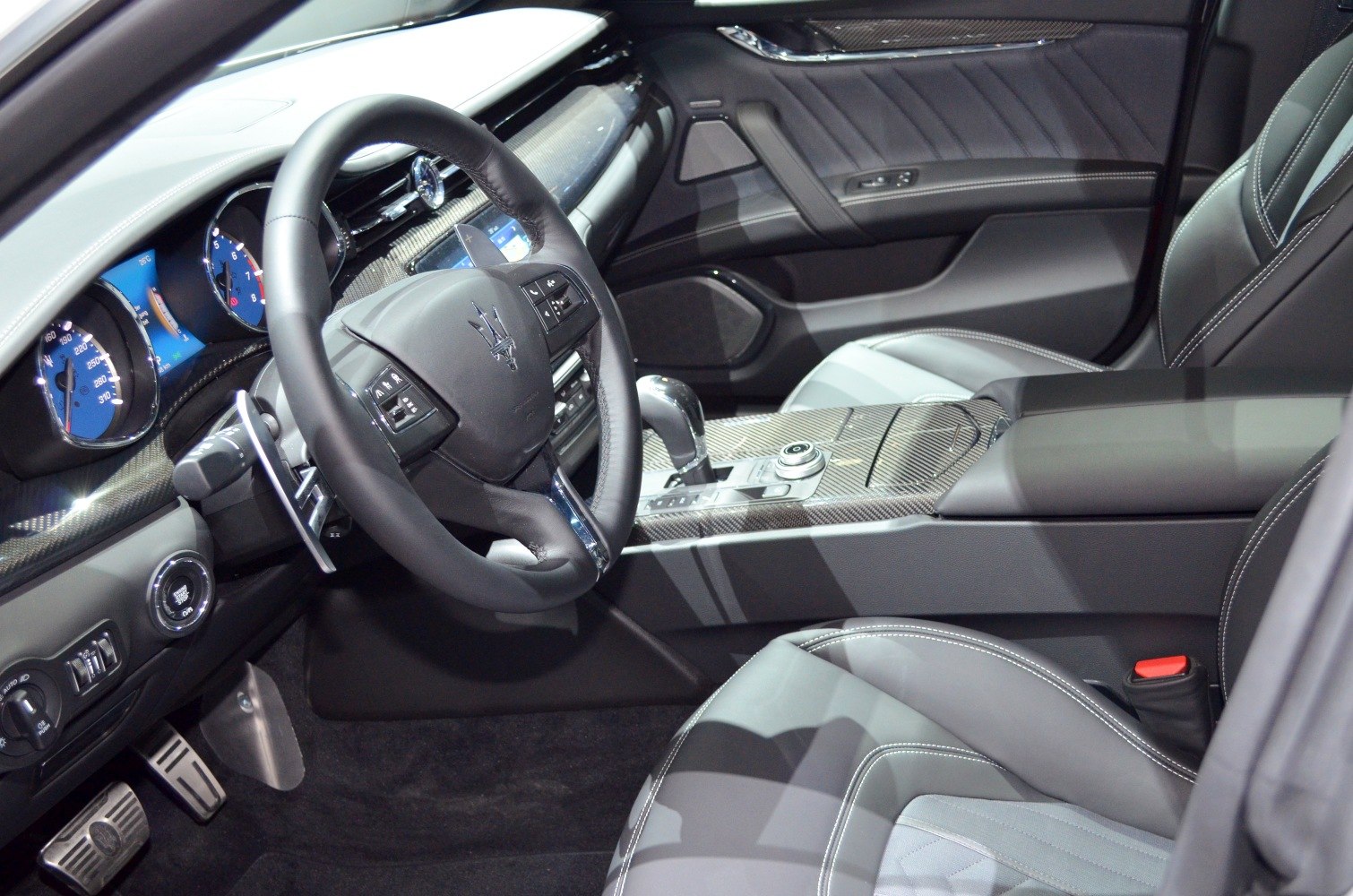 Luxury interior with carbon fiber dashboard and blue digital gauges