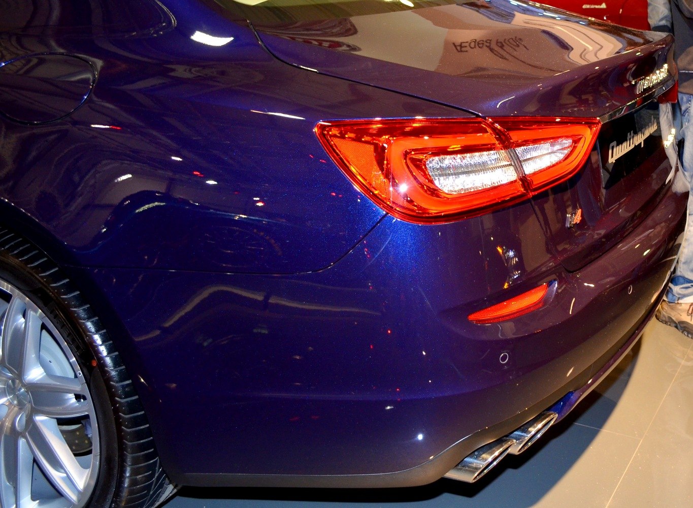 Rear taillight, dual exhaust tips, alloy wheel close-up