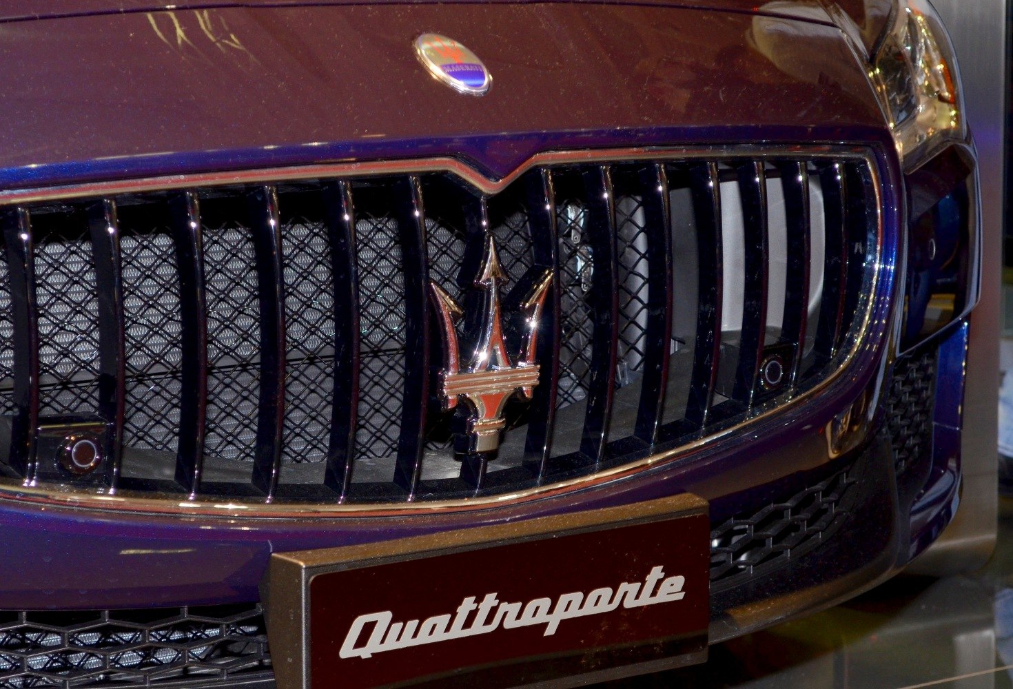 Close-up of front grille with trident emblem and model name plate