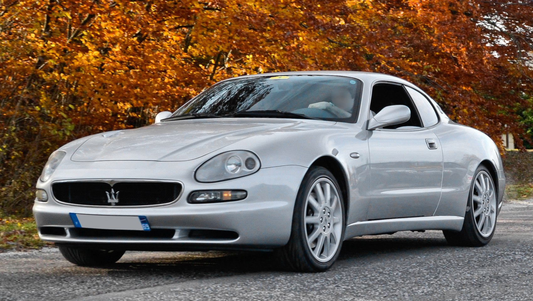Silver coupe with rounded headlights and sporty front grille.