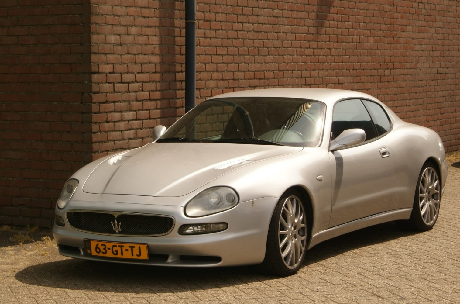 Silver sports coupe front three-quarter view with distinctive headlights