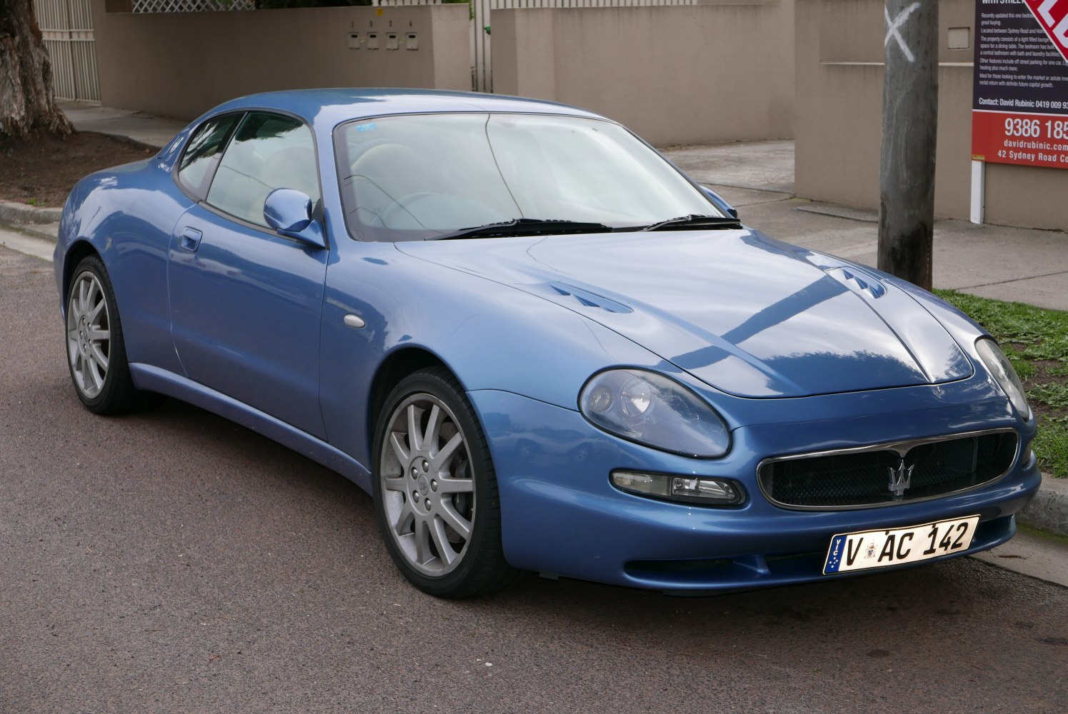 Blue coupe front side view with sleek hood and distinct headlights