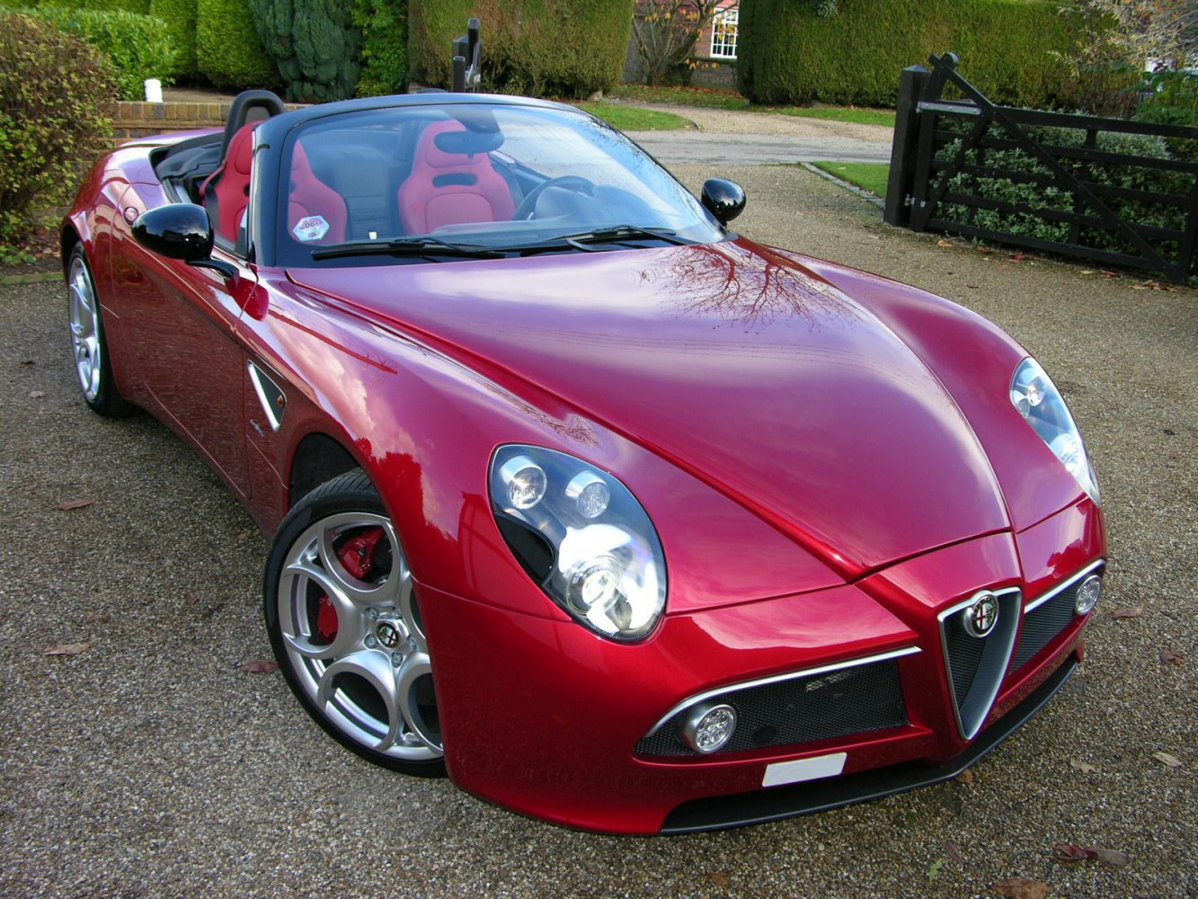 Convertible front view with red metallic finish and sporty alloy wheels