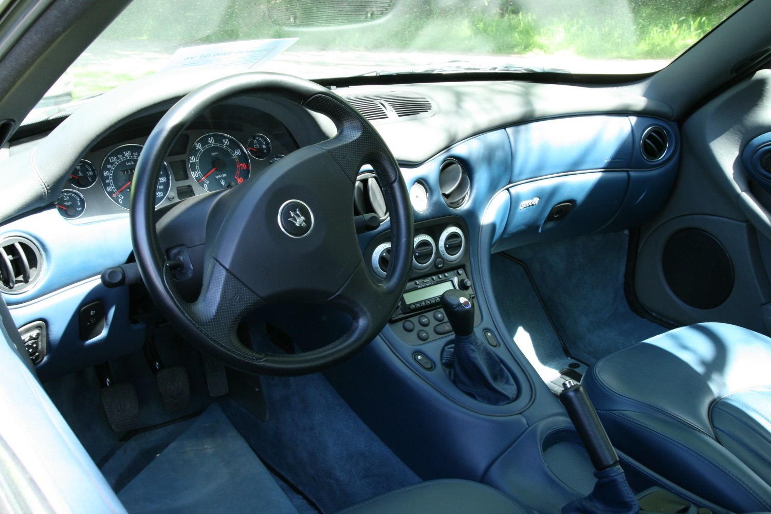 Sporty blue leather interior with manual gearshift and detailed dashboard cluster
