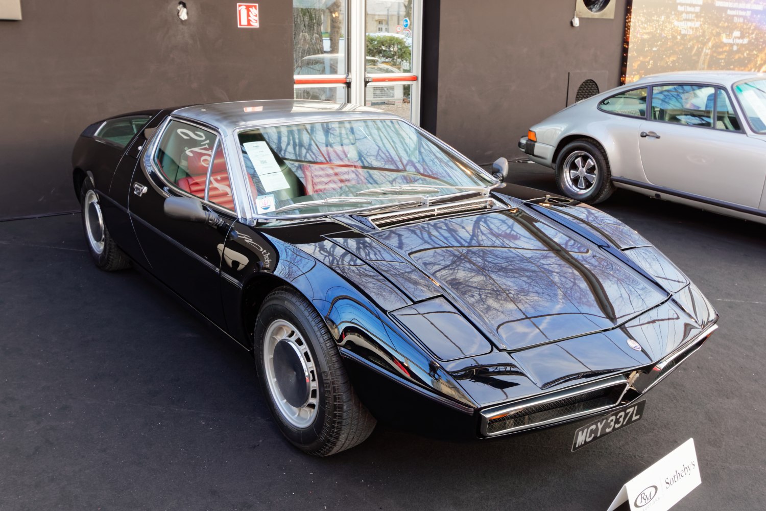 Low front sportscar with hood vents and red interior