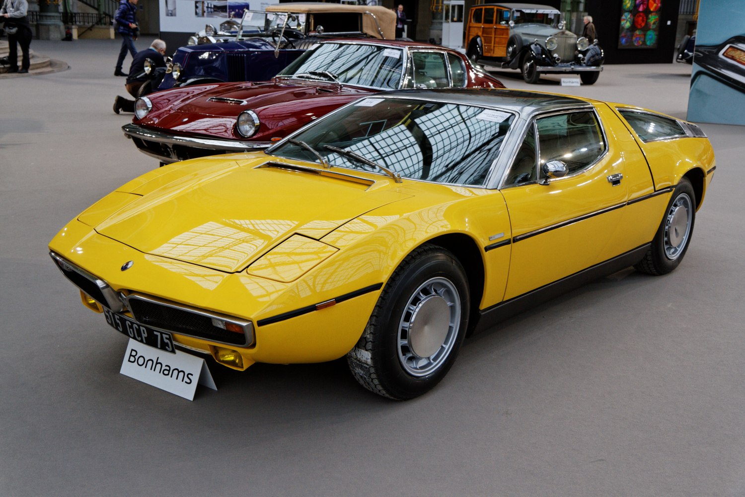 Yellow classic sports coupe with pop-up headlights and chrome roof