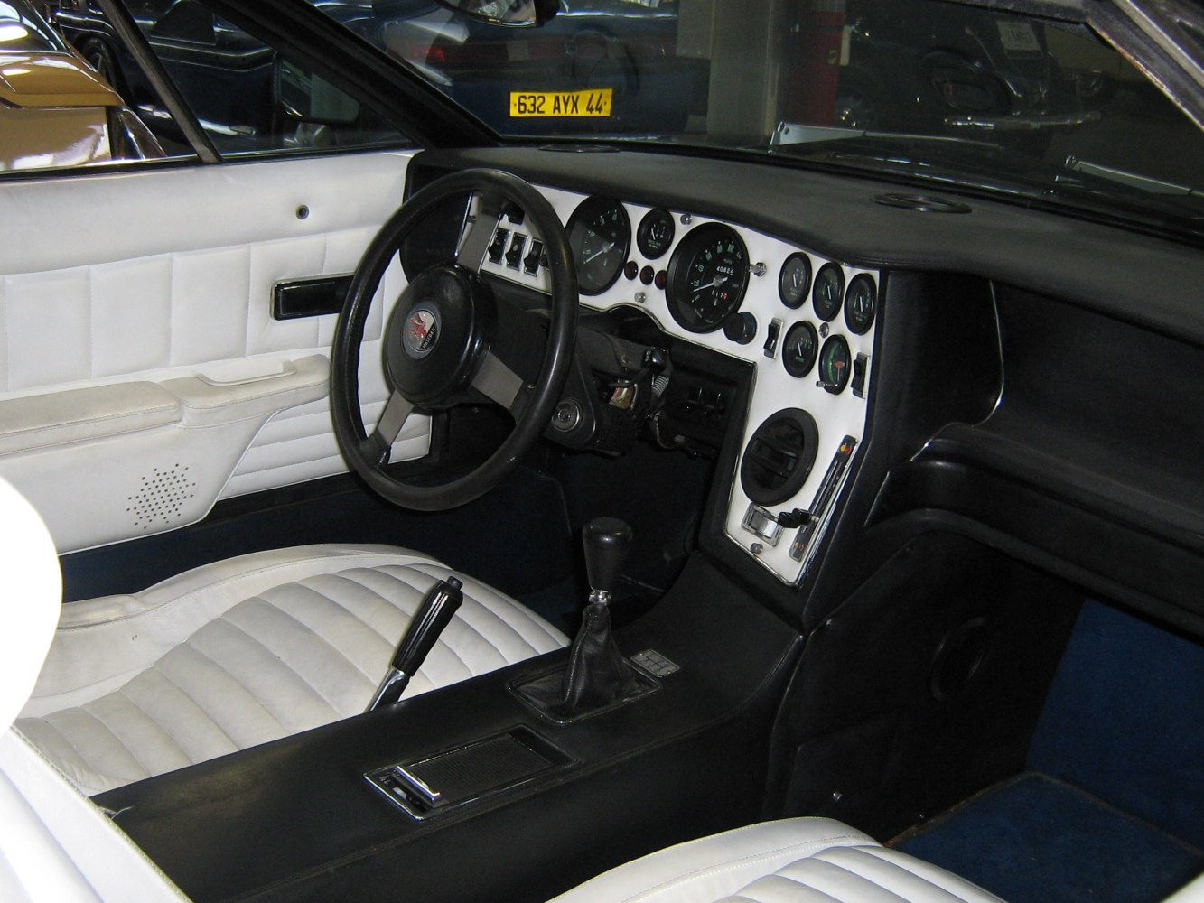 Vintage car interior with white leather seats and detailed dashboard gauges