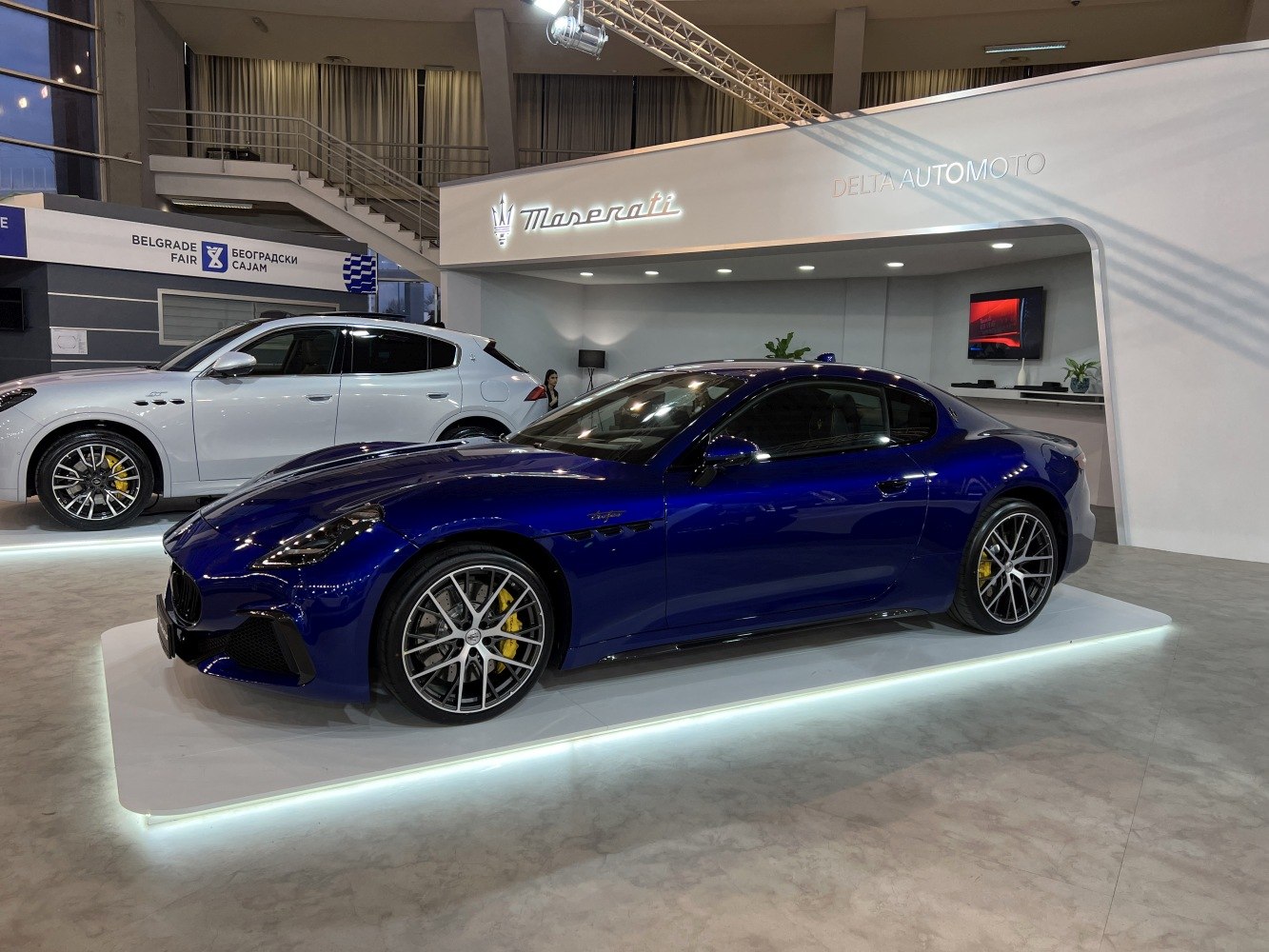 Glossy blue sports coupe with multi-spoke alloy wheels and yellow brake calipers