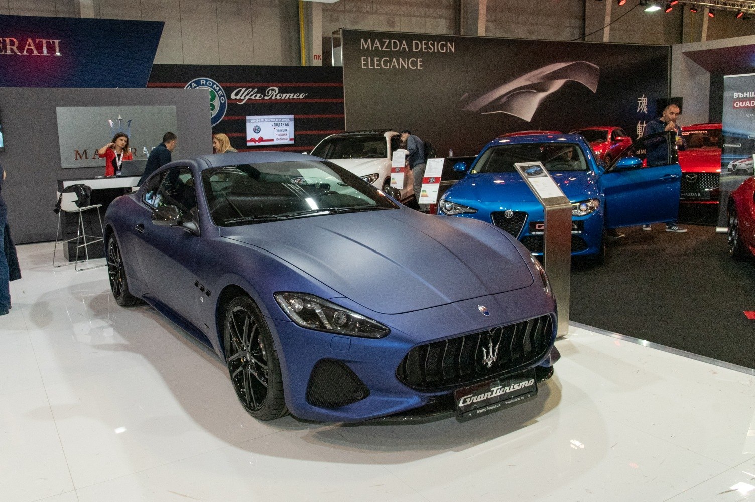 Matte blue sports coupe front with aggressive grille and sleek headlights