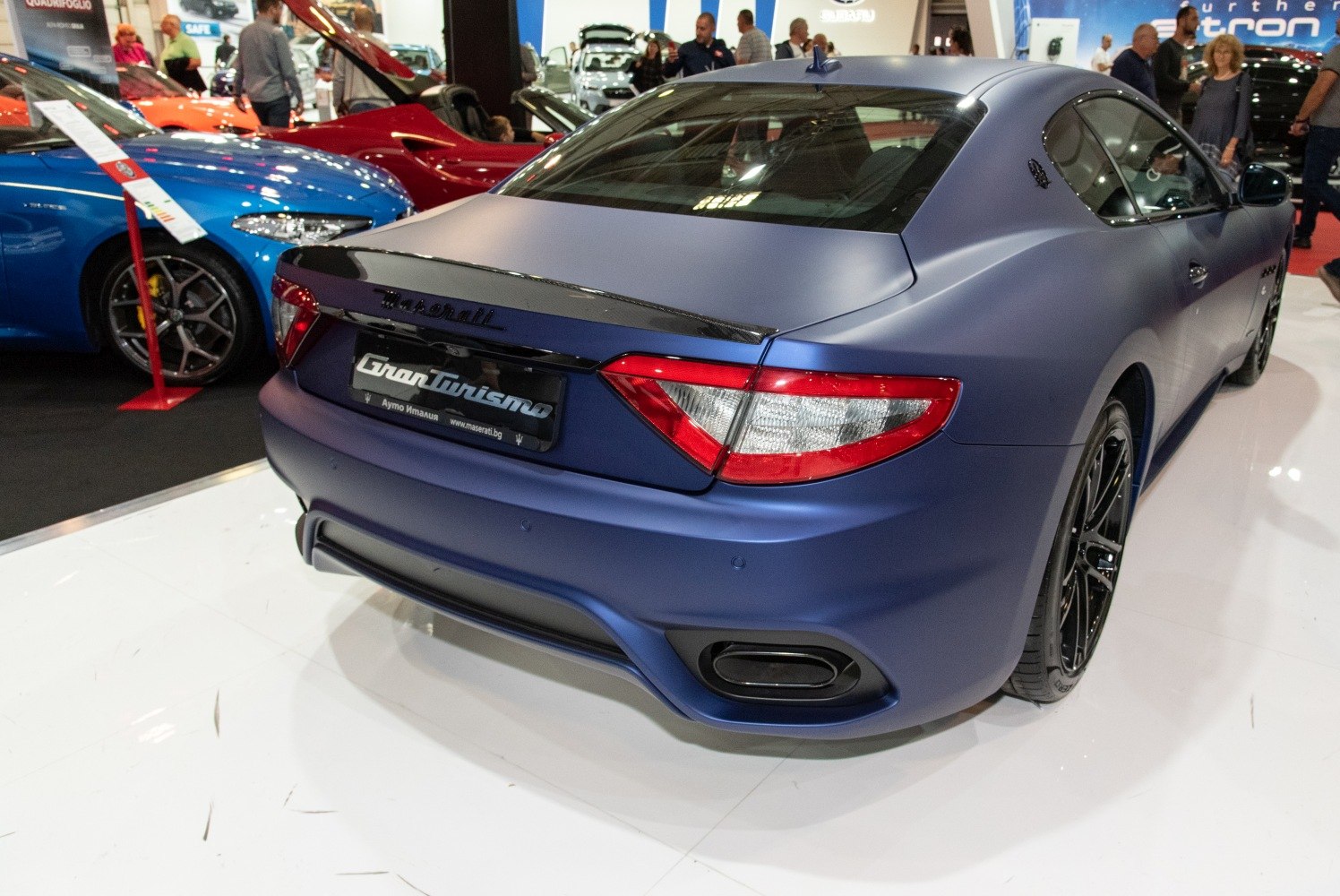 Rear view with taillights, spoiler, diffuser, and black alloy wheels