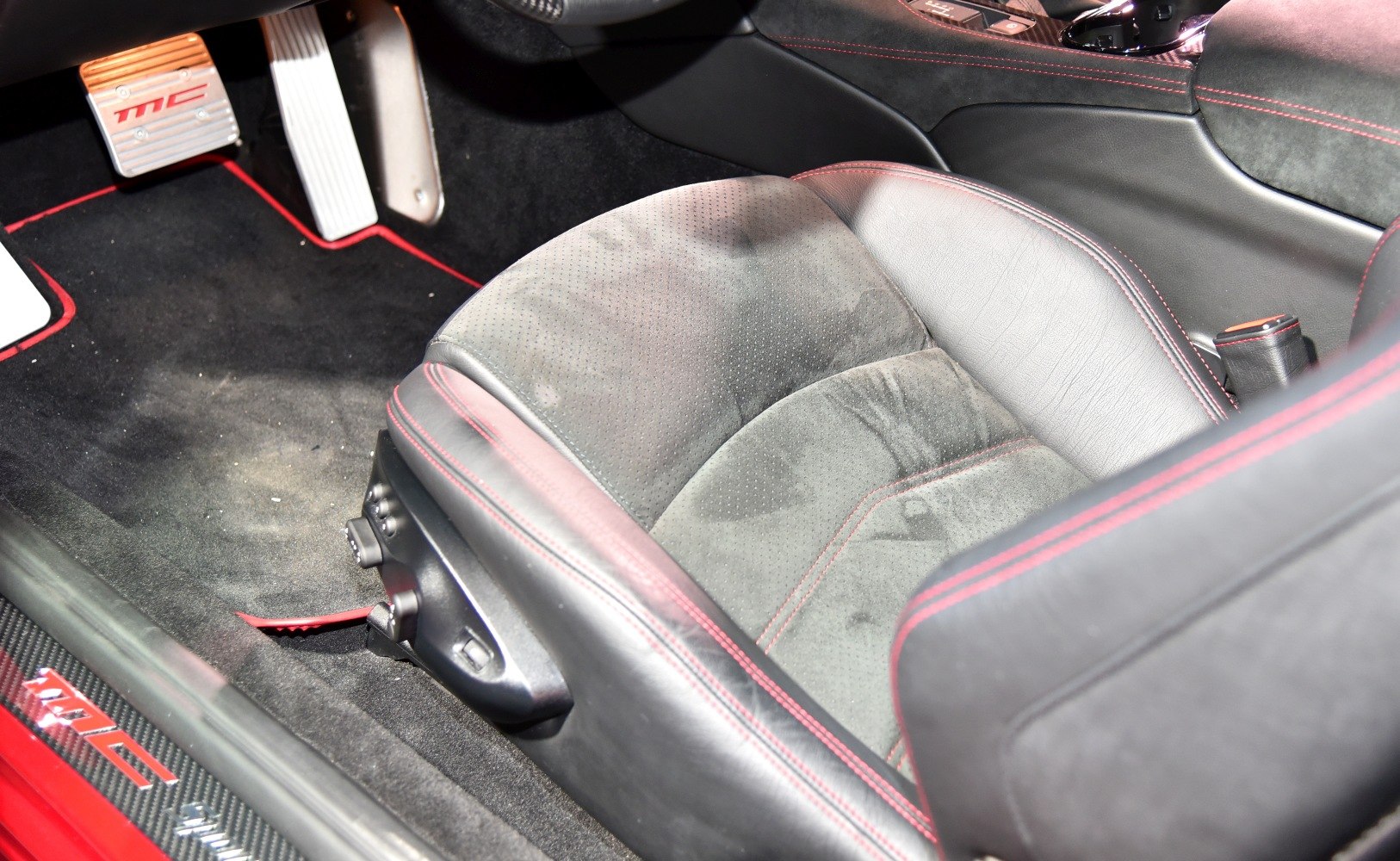 Leather and suede seat with red stitching and sports pedals