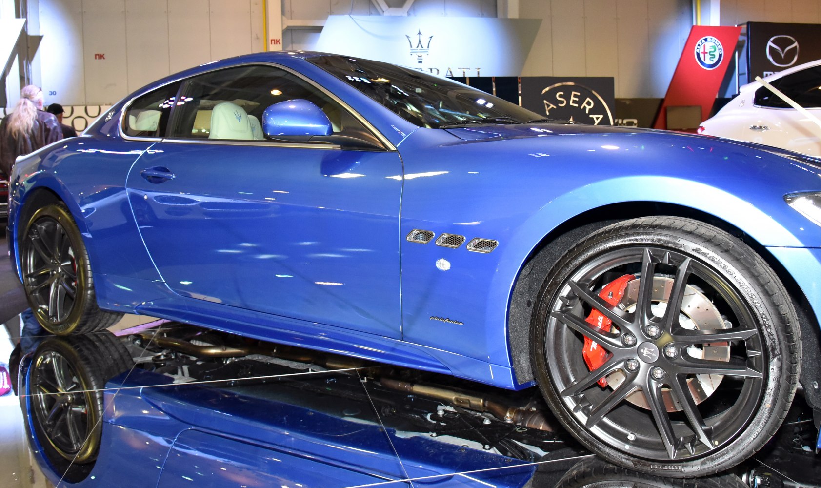 Blue coupe side profile with black alloy wheel and red brake caliper