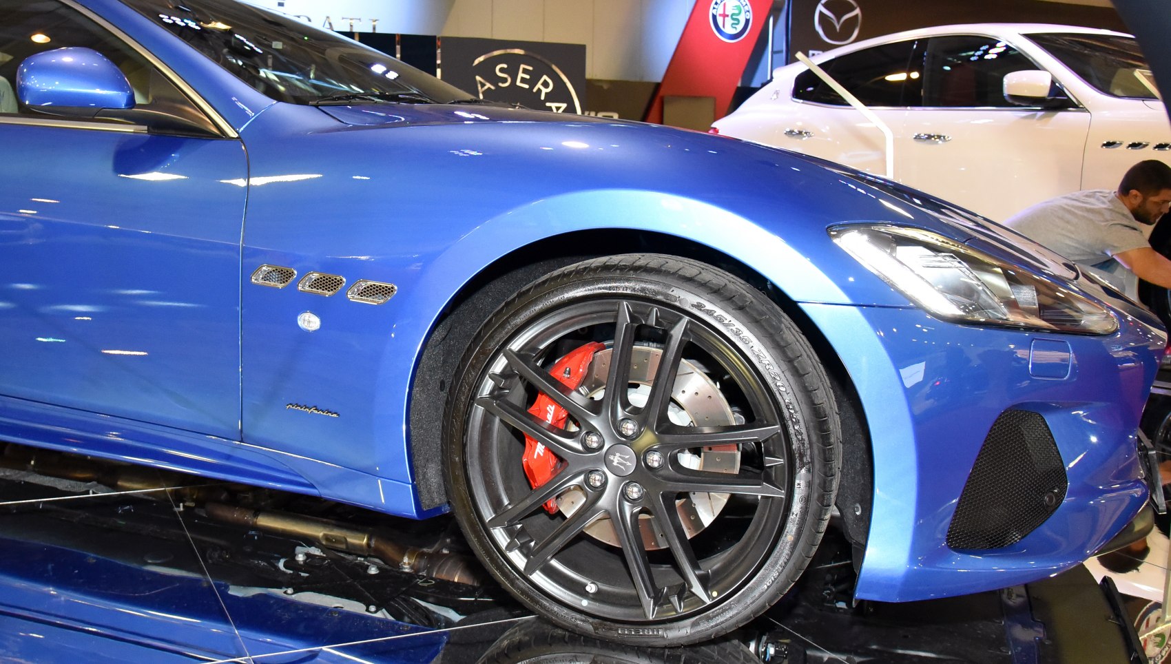 Close-up of front wheel with red brake caliper and side vents