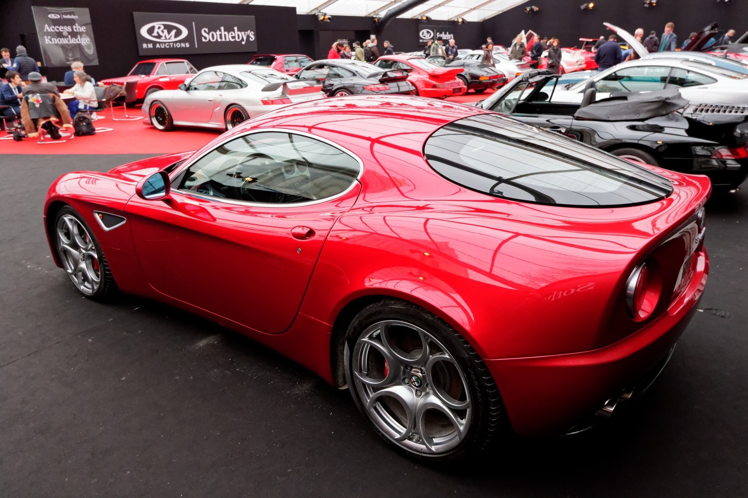 Rear and side view of red sports coupe with round tail lights and alloys